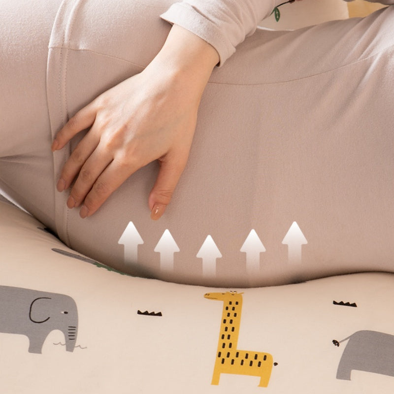 mere enceinte touche ventre sur coussin de grossesse