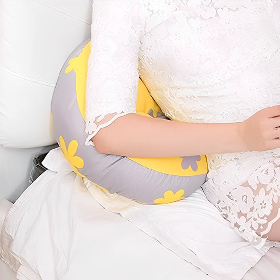 bras femme enciente sur coussin de grossesse