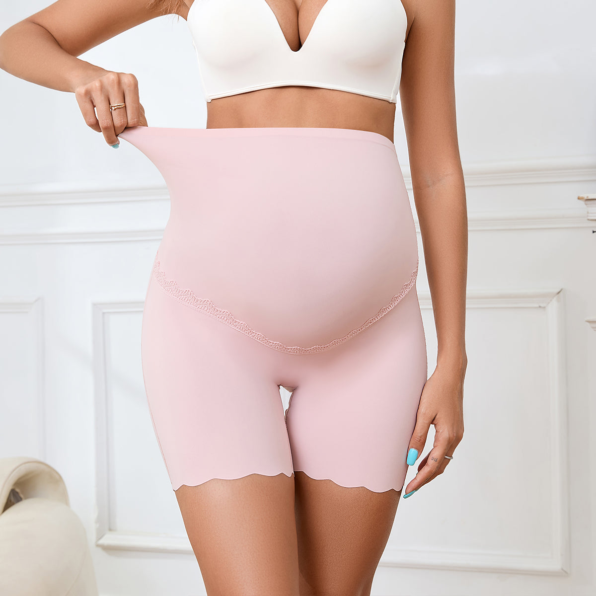 femme enceinte portant culotte grossesse rose de main sur la culotte