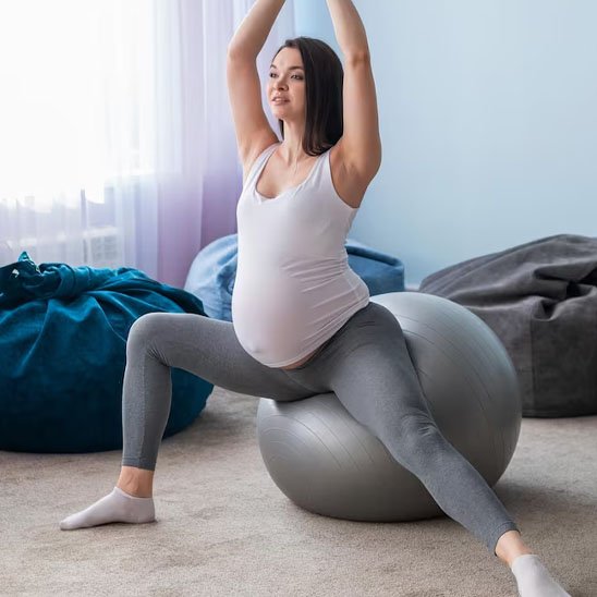 mere enceinte en execice avec ballon de grossesse